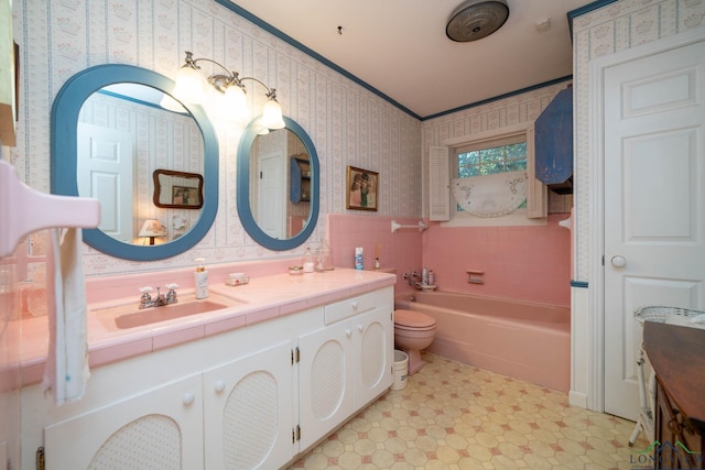 bathroom with crown molding, a washtub, vanity, and toilet