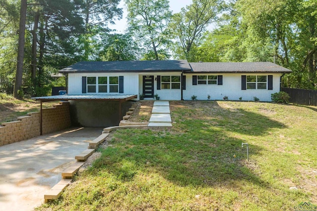 ranch-style home featuring fence, a carport, a front lawn, and concrete driveway