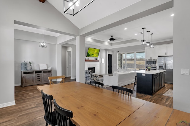 dining room featuring dark hardwood / wood-style floors, lofted ceiling, sink, ceiling fan, and crown molding