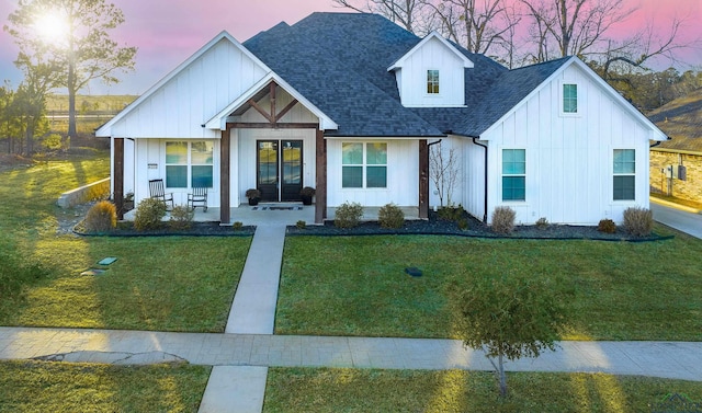 modern farmhouse with covered porch and a lawn