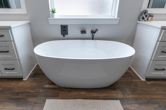 bathroom with vanity, hardwood / wood-style flooring, and a bathing tub