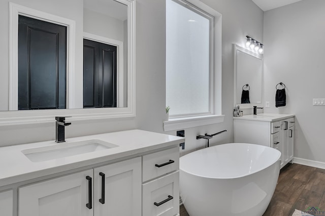 4205 Savannah Hills Ln, Longview, TX 75605 - bathroom featuring vanity, a freestanding tub, and wood finished floors