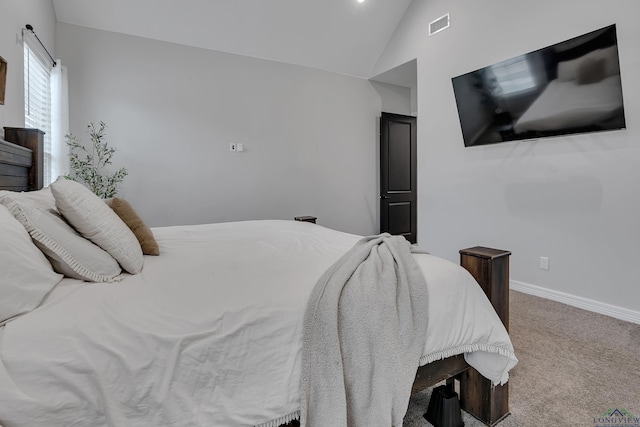 carpeted bedroom with lofted ceiling