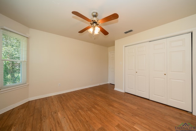 unfurnished bedroom featuring ceiling fan, a closet, and light hardwood / wood-style floors