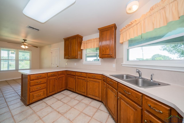 kitchen with kitchen peninsula, ceiling fan, and sink