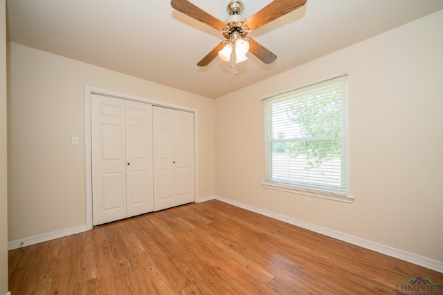 unfurnished bedroom with a closet, light hardwood / wood-style flooring, and ceiling fan