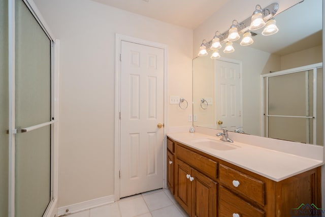 bathroom featuring tile patterned flooring, vanity, and a shower with shower door