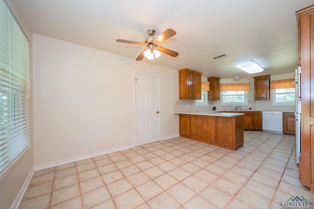 kitchen with kitchen peninsula, ceiling fan, sink, and white dishwasher