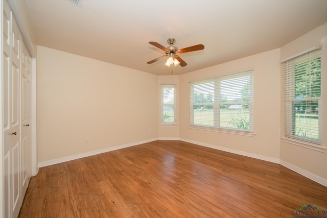 unfurnished room with ceiling fan and hardwood / wood-style flooring