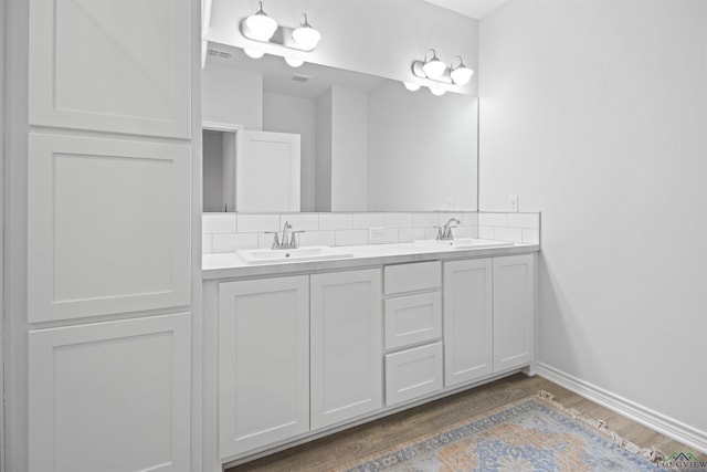 bathroom with vanity, hardwood / wood-style floors, and decorative backsplash