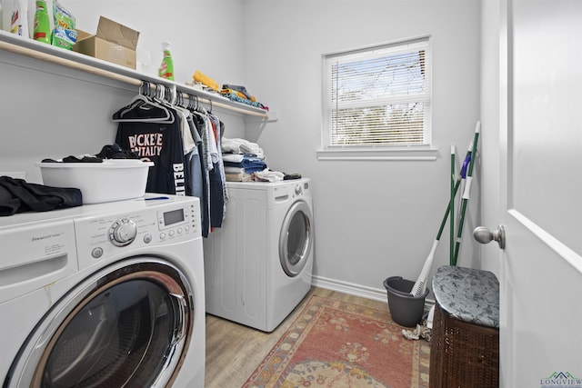 clothes washing area with separate washer and dryer and light wood-type flooring