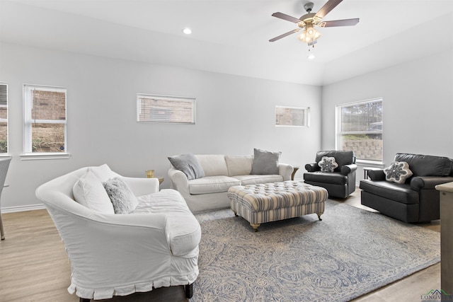 living room with lofted ceiling, light wood-type flooring, and ceiling fan