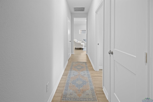 hallway with light hardwood / wood-style floors