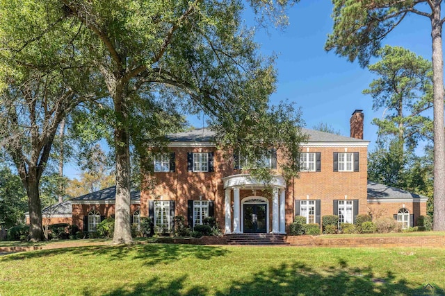 colonial home featuring a front lawn