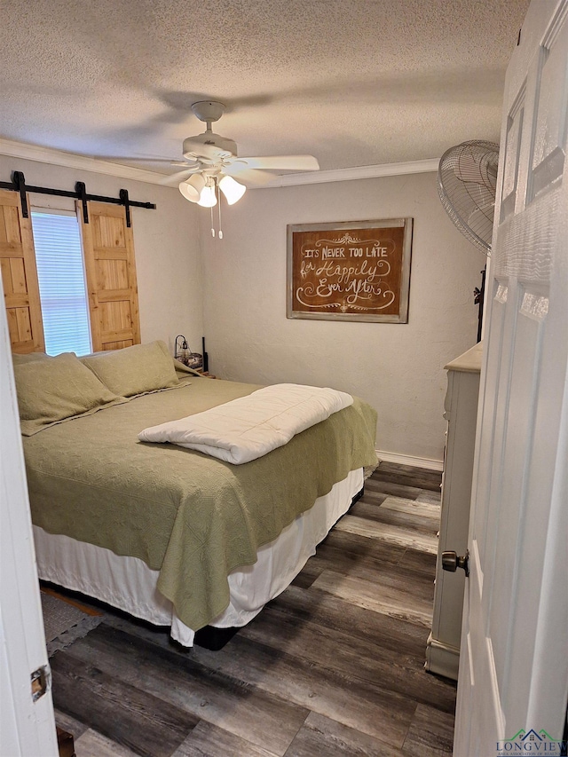 bedroom featuring dark hardwood / wood-style floors, ceiling fan, a barn door, and a textured ceiling