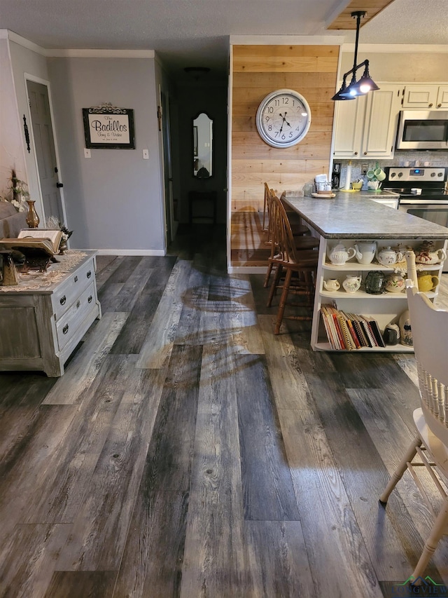 interior space with dark wood-type flooring, ornamental molding, wooden walls, and a textured ceiling