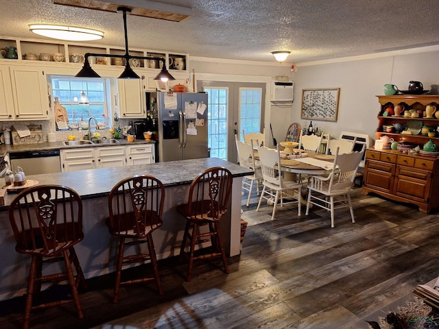 dining area featuring dark wood-type flooring, sink, french doors, and an AC wall unit