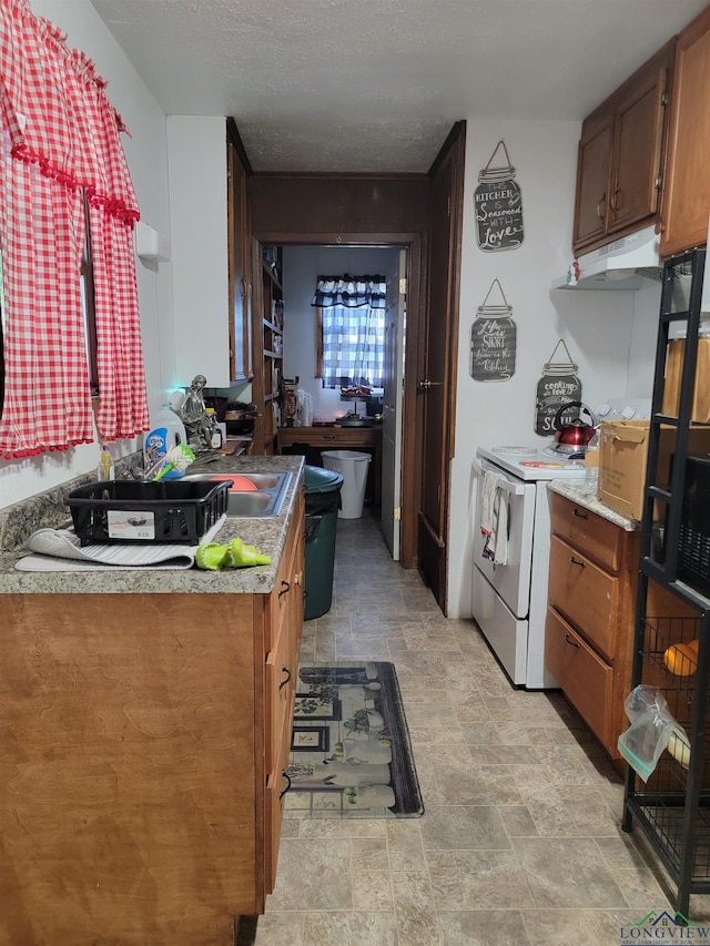 kitchen featuring sink, a textured ceiling, and range