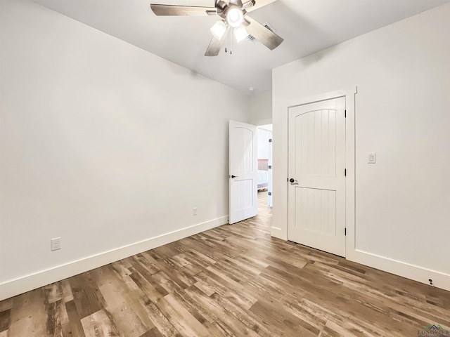 unfurnished bedroom with ceiling fan and hardwood / wood-style floors