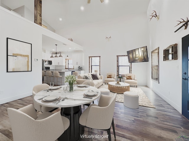 dining area featuring hardwood / wood-style flooring and high vaulted ceiling