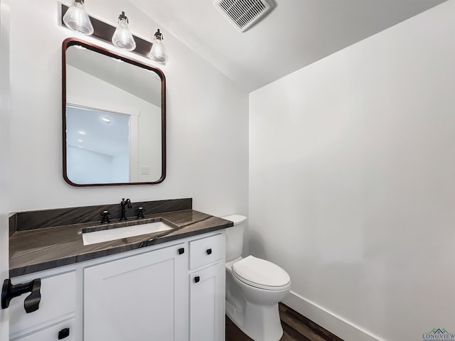 bathroom with vanity, hardwood / wood-style floors, and toilet