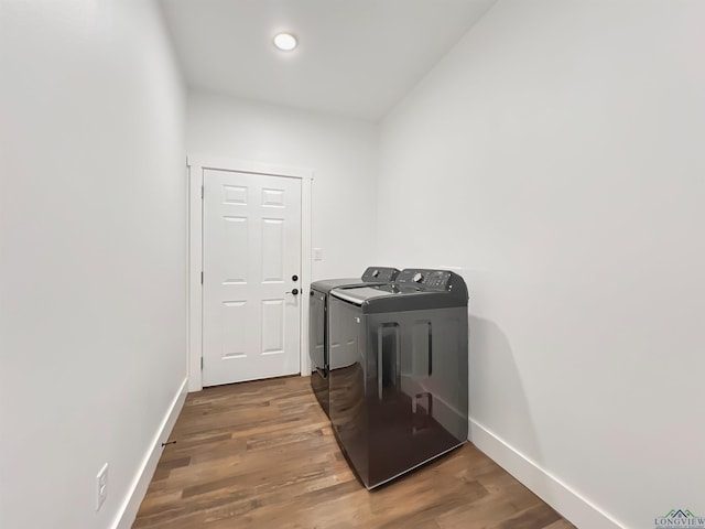 washroom with hardwood / wood-style flooring and washer and clothes dryer