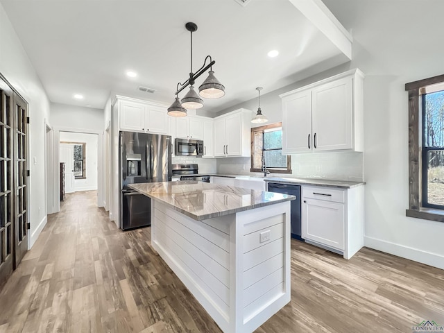 kitchen with a center island, white cabinets, and appliances with stainless steel finishes