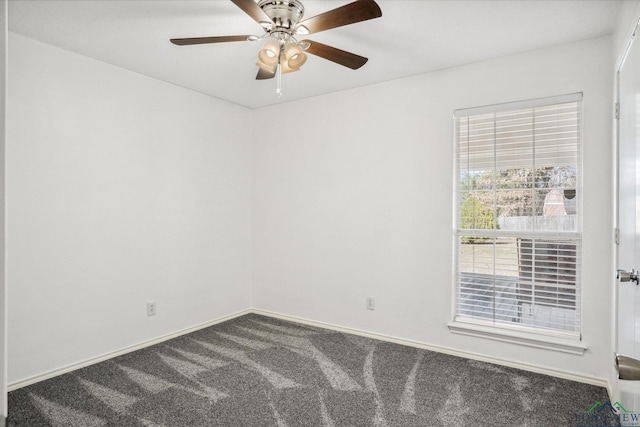 carpeted spare room featuring ceiling fan and baseboards