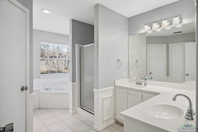 bathroom featuring a stall shower, tile patterned flooring, a sink, and a bath