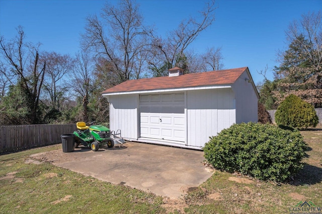 detached garage featuring fence