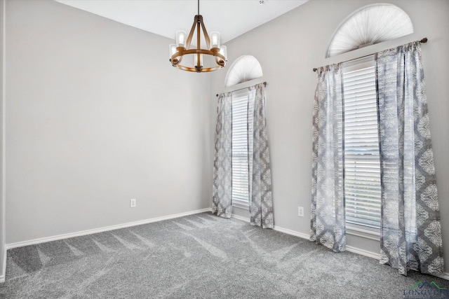 carpeted empty room with baseboards and a notable chandelier