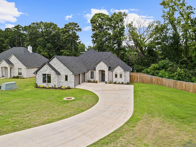 french provincial home with a front yard and a garage