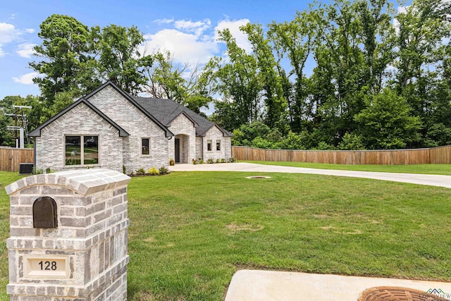 french country style house featuring cooling unit and a front yard