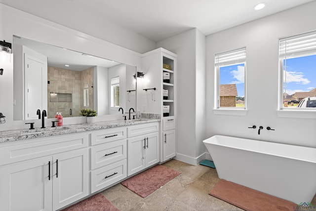 bathroom featuring shower with separate bathtub, vanity, and a healthy amount of sunlight