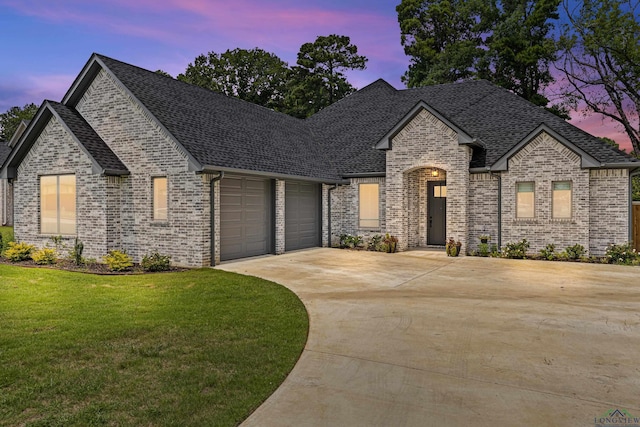 french provincial home with a yard and a garage