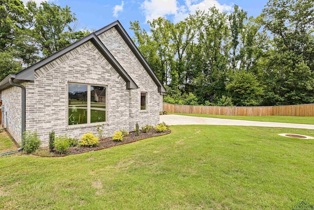 view of side of home with a yard