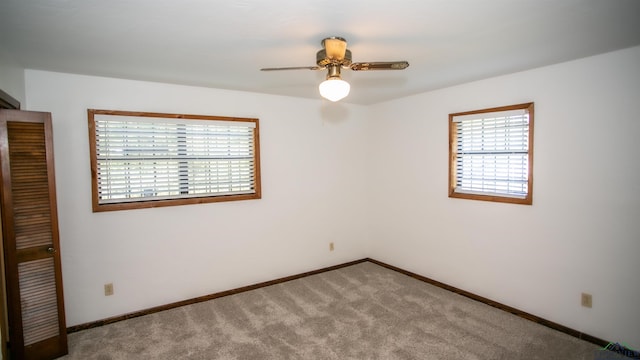 carpeted spare room with ceiling fan