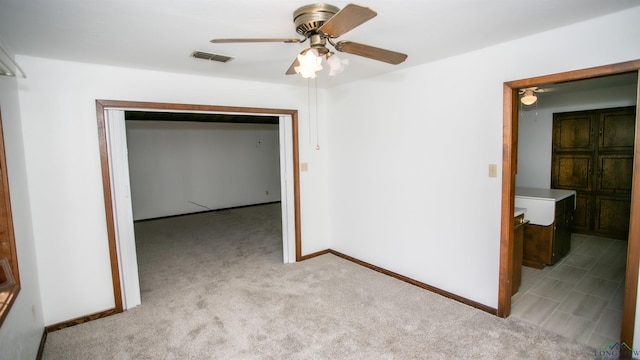 unfurnished room featuring light colored carpet and ceiling fan