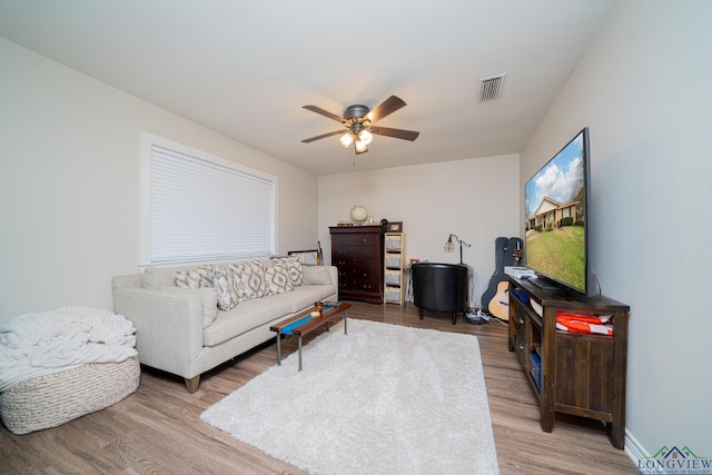 living room featuring ceiling fan and hardwood / wood-style floors