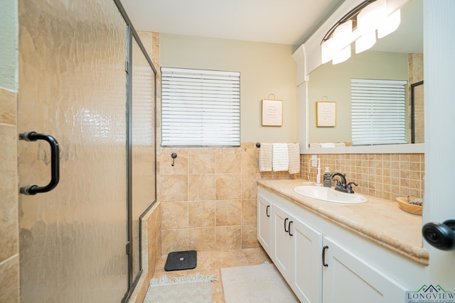 bathroom featuring vanity, tile walls, and walk in shower