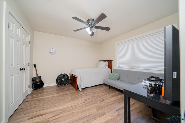 bedroom featuring ceiling fan, light hardwood / wood-style floors, and a closet