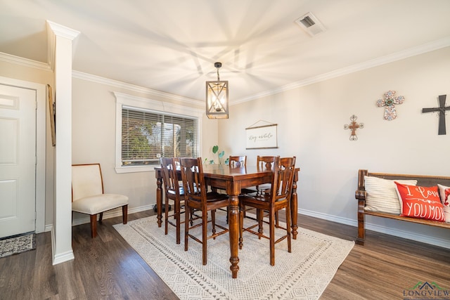 dining space with dark hardwood / wood-style flooring, ornamental molding, and an inviting chandelier