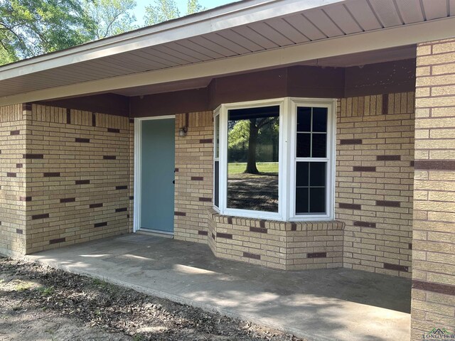view of exterior entry featuring brick siding