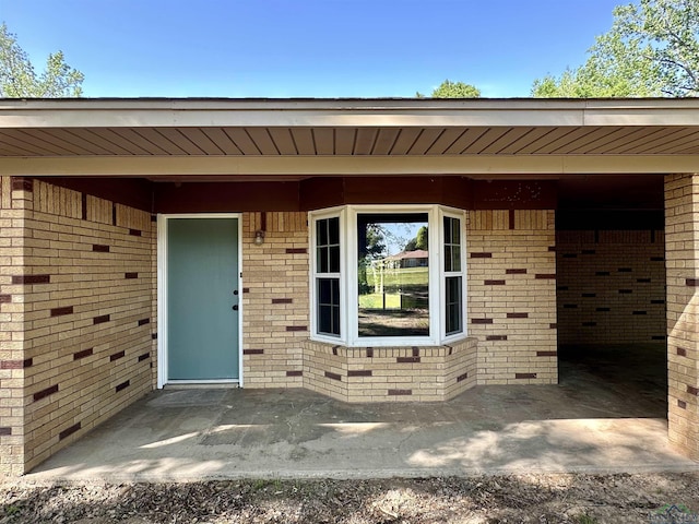 view of exterior entry with brick siding