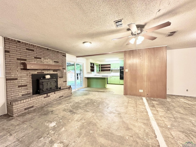unfurnished living room with a textured ceiling, ceiling fan, and visible vents