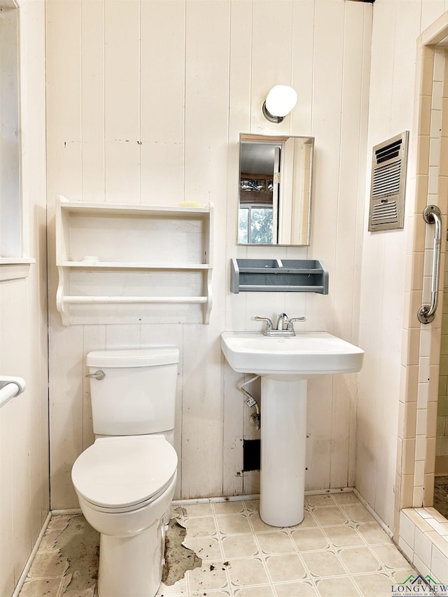 bathroom with visible vents, a sink, a tile shower, toilet, and tile patterned floors