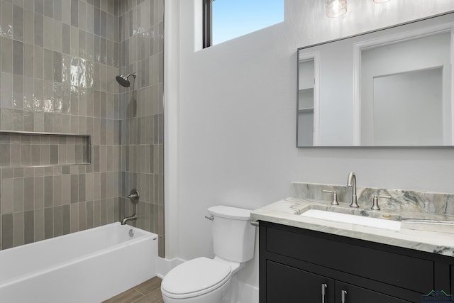 full bathroom featuring hardwood / wood-style flooring, vanity, toilet, and tiled shower / bath combo