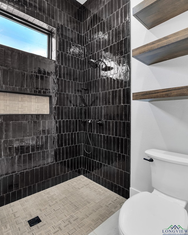 bathroom with tiled shower and toilet