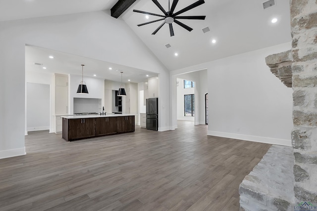 unfurnished living room featuring sink, ceiling fan, high vaulted ceiling, dark hardwood / wood-style flooring, and beamed ceiling