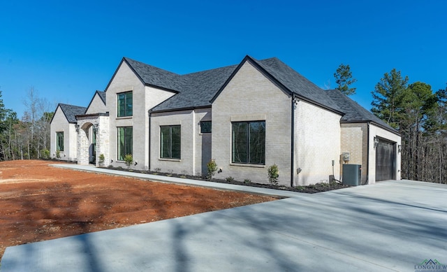 french country home with central AC and a garage